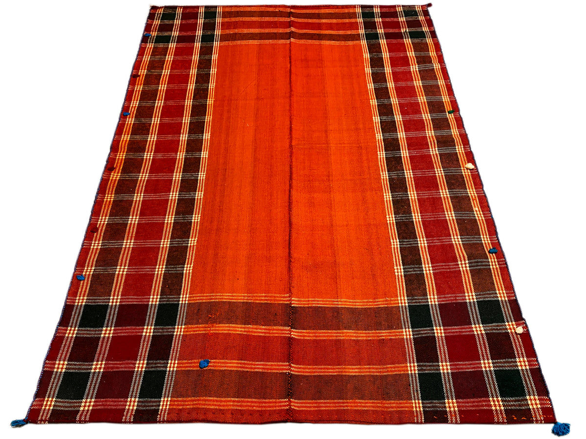 Tappeto Jajim, disposto obliquamente: superficie rosso-arancio con bordo a quadri scuri e fissaggi blu