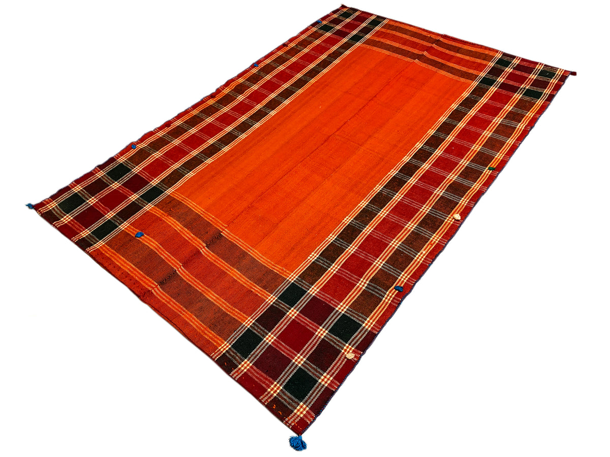 Tappeto Jajim in rosso-arancio e marrone scuro: strisce diagonali a rombi, angoli con nappine blu