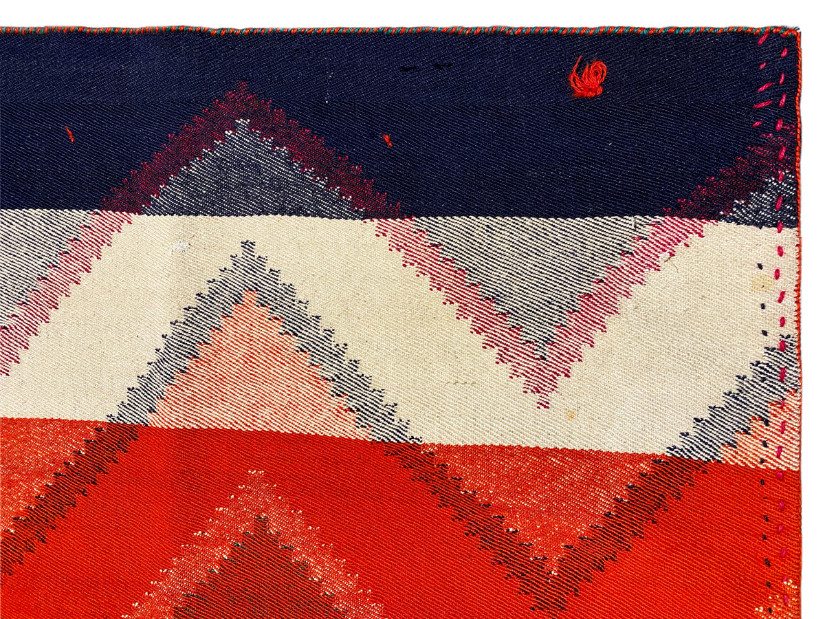 Bordo del tappeto con cucitura e motivo geometrico in blu scuro, crema, rosso e grigio