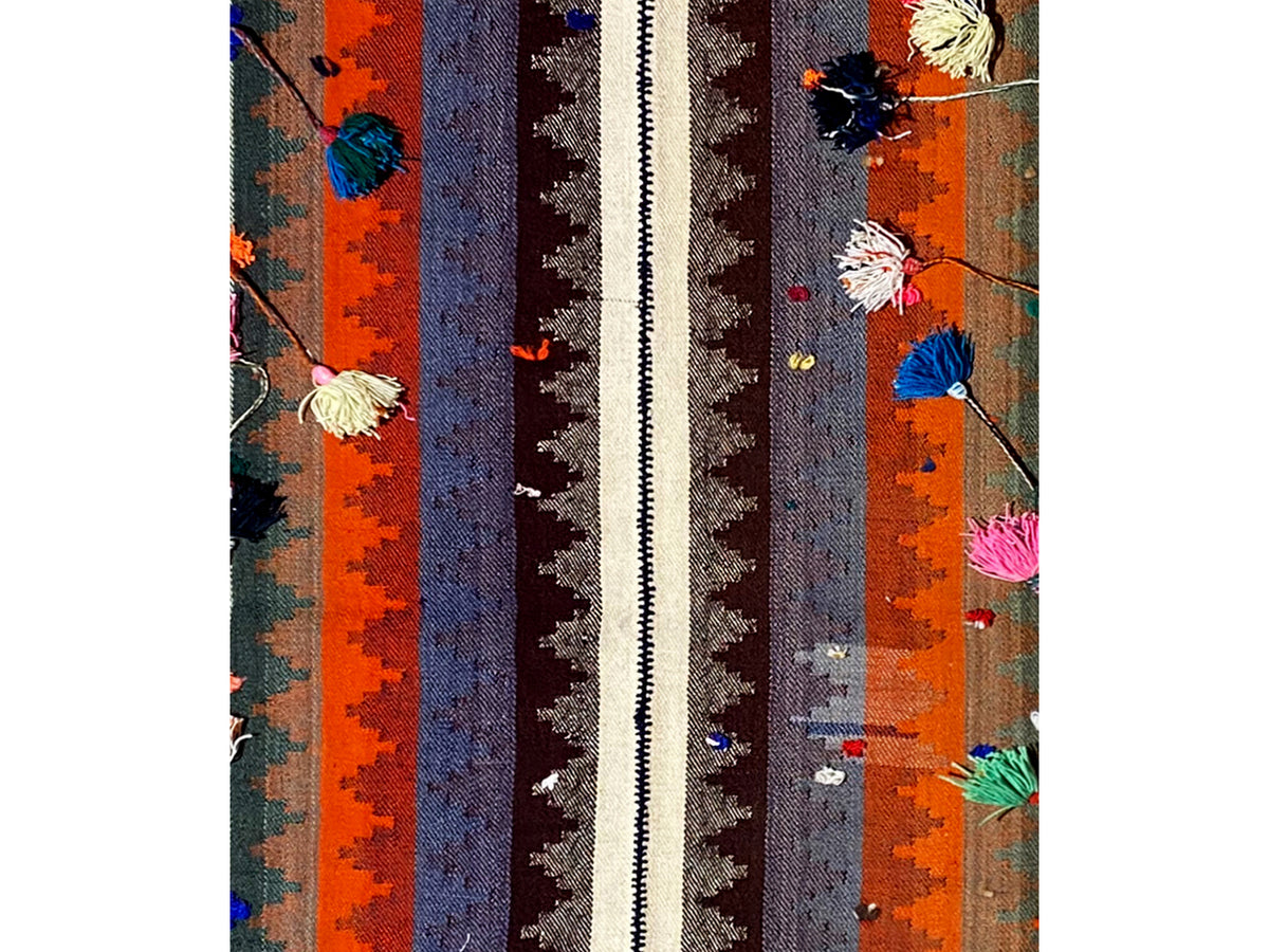 Primo piano: tappeto con strisce verticali e ornamenti floreali variopinti