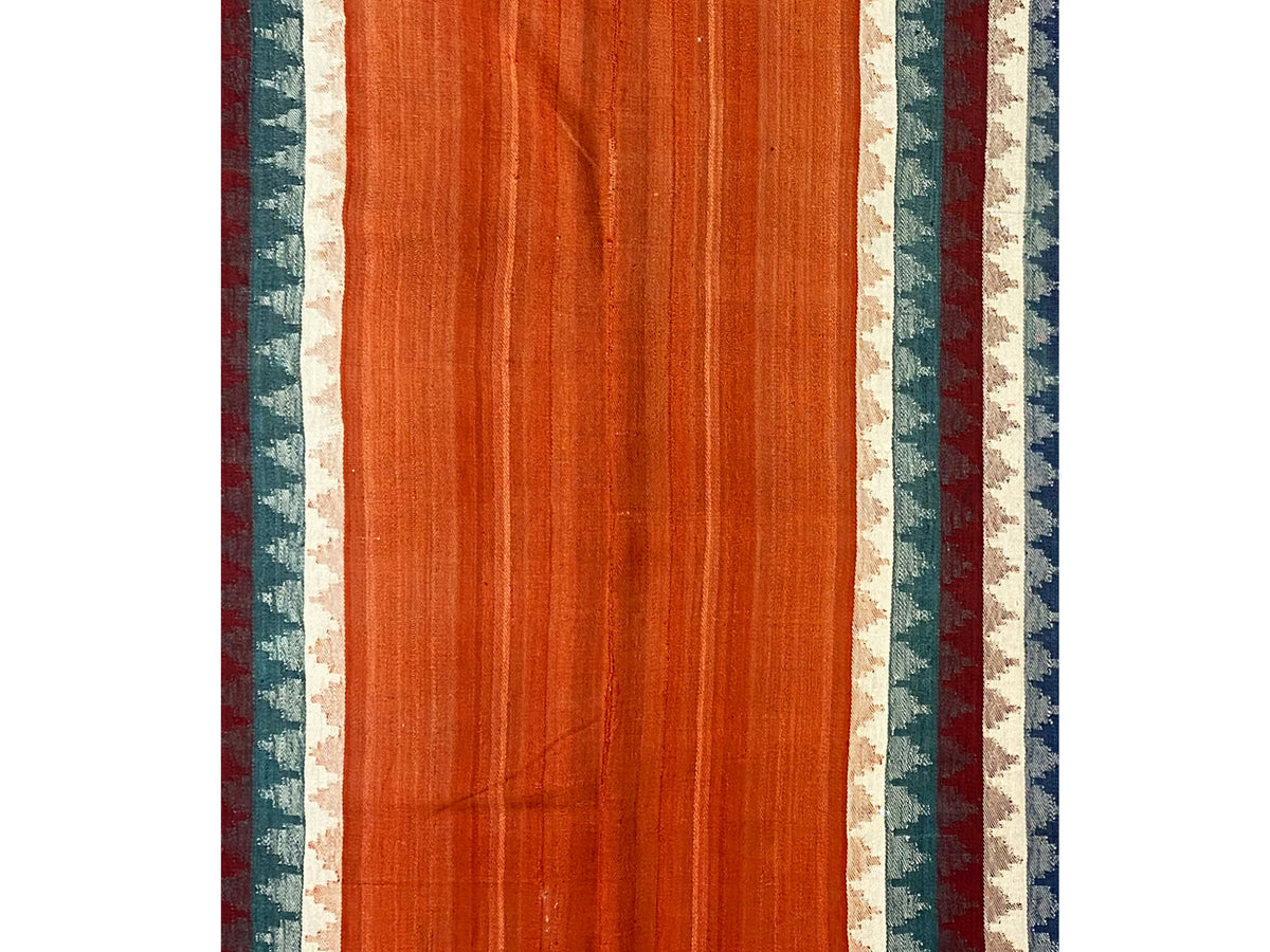 Tappeto Jajim, vista frontale: superficie uniforme color terracotta con bordure laterali a righe