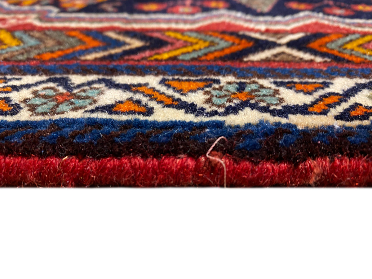Primo piano del bordo del tappeto Poshti con pelo fitto e bordo rosso