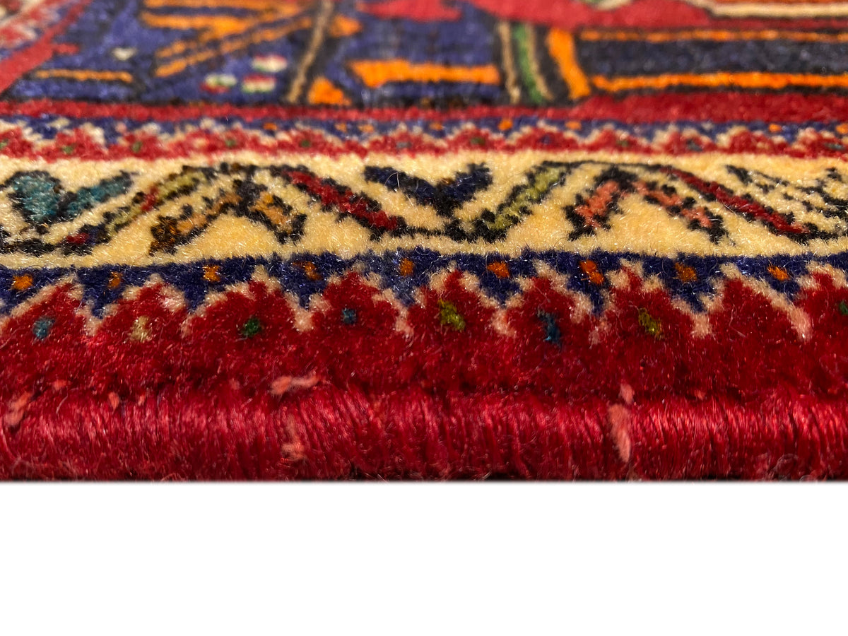 Tappeto Poshti 66x62 cm Dettaglio del bordo: pelo rosso fitto con bordura colorata.