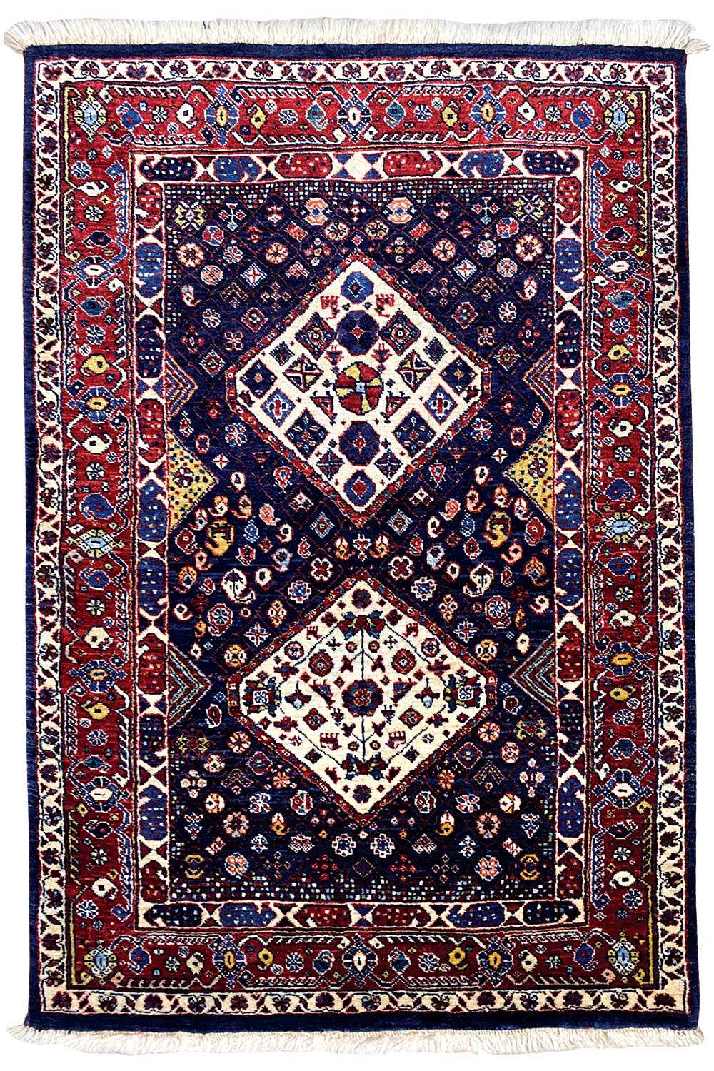 Tappeto blu scuro, con bordo rosso, motivo centrale a diamanti e frange