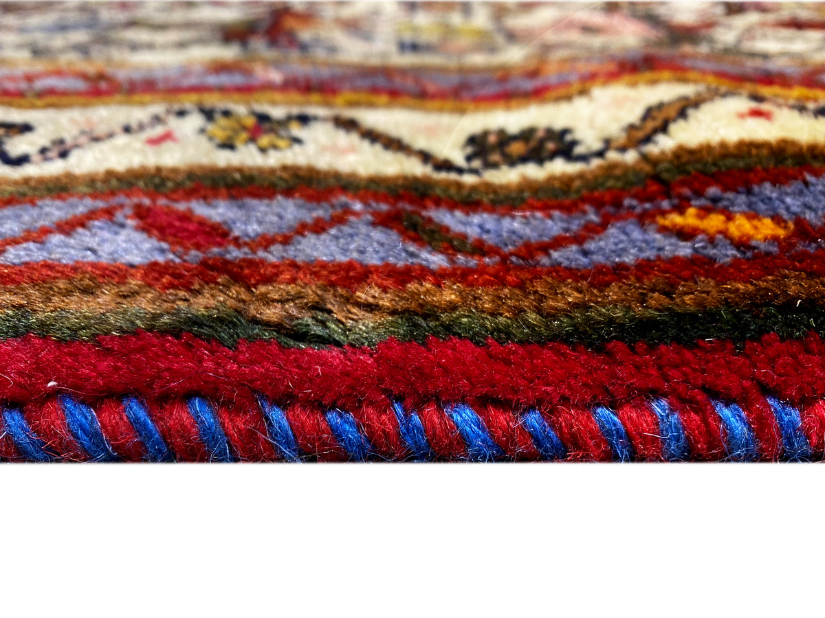 Primo piano: bordo del tappeto con frange rosse e blu e strisce a motivi colorati