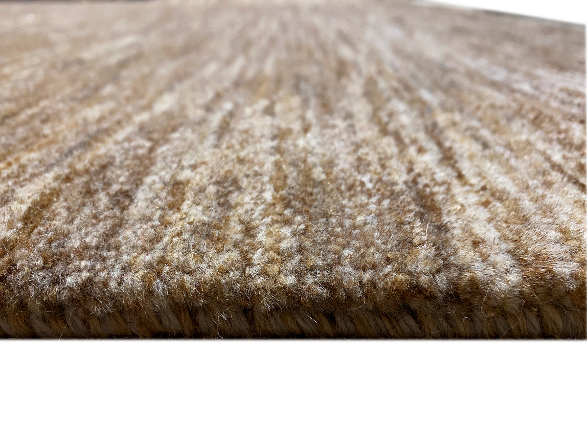 Dettaglio del tappeto Gabbeh: vello marrone-beige, consistenza compatta a pelo corto sul bordo