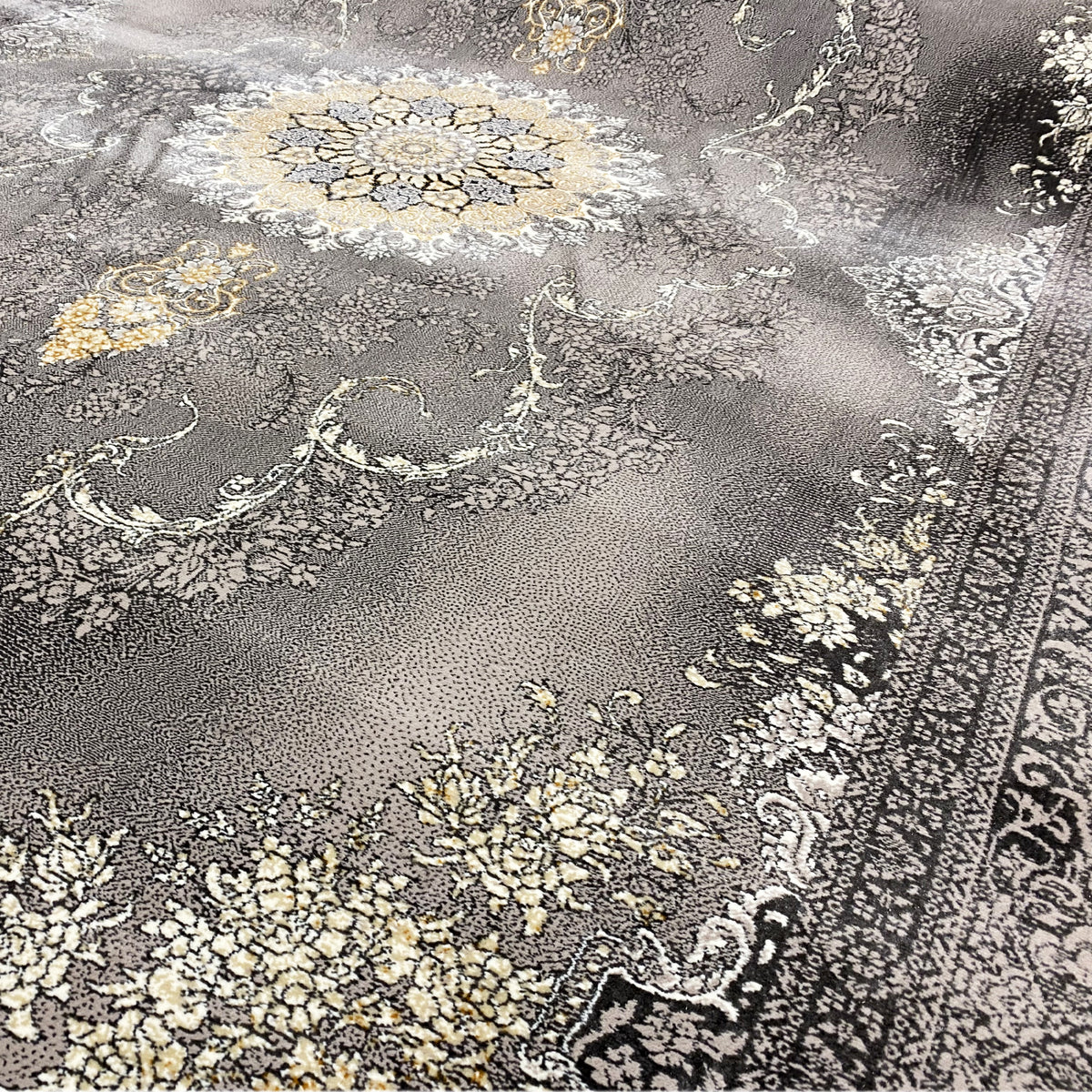 Vista dettagliata del tappeto Kashan: vello grigio con ornamenti floreali in oro e beige