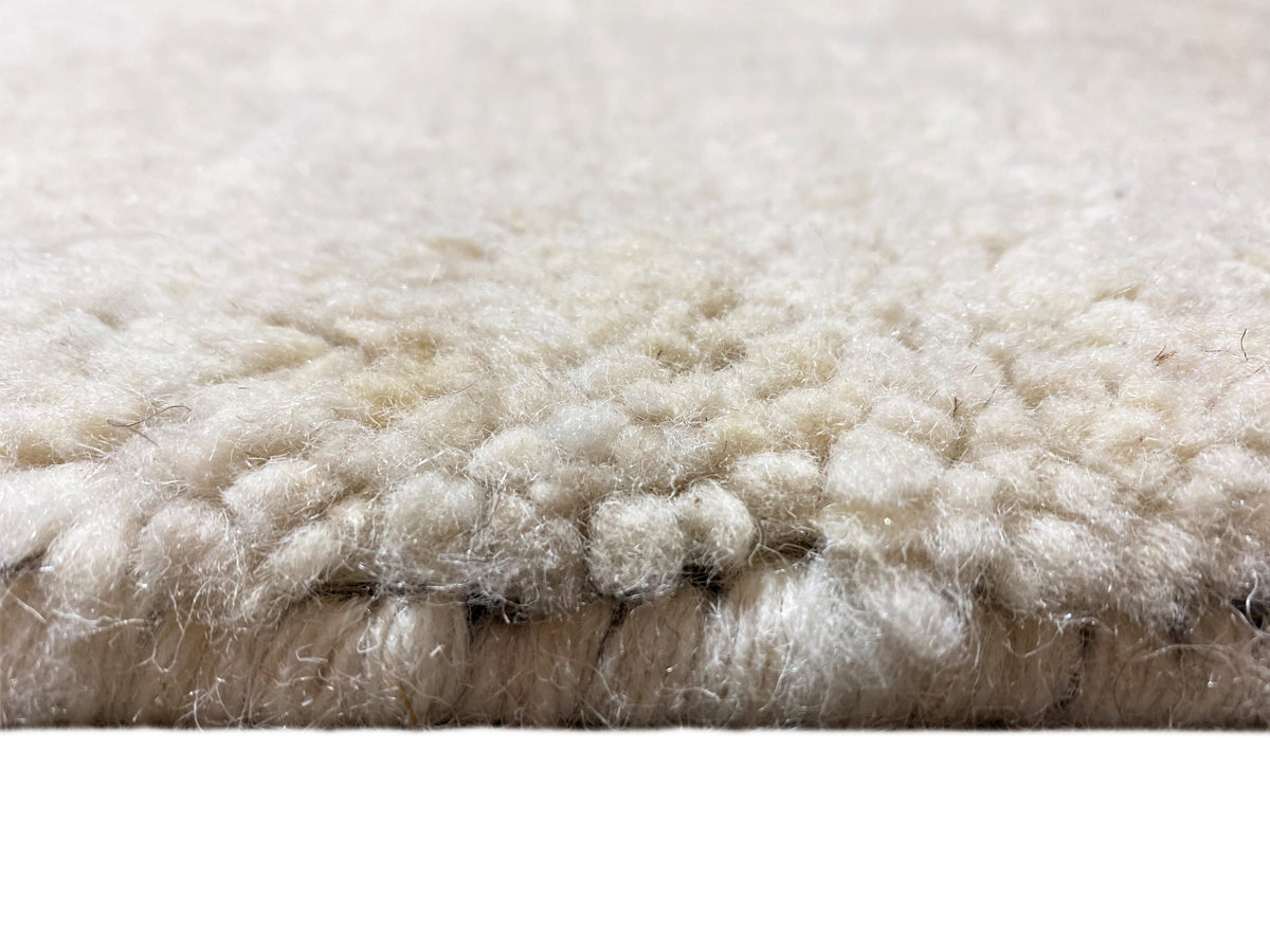 Vista laterale: folto vello color crema con bordo inferiore blu