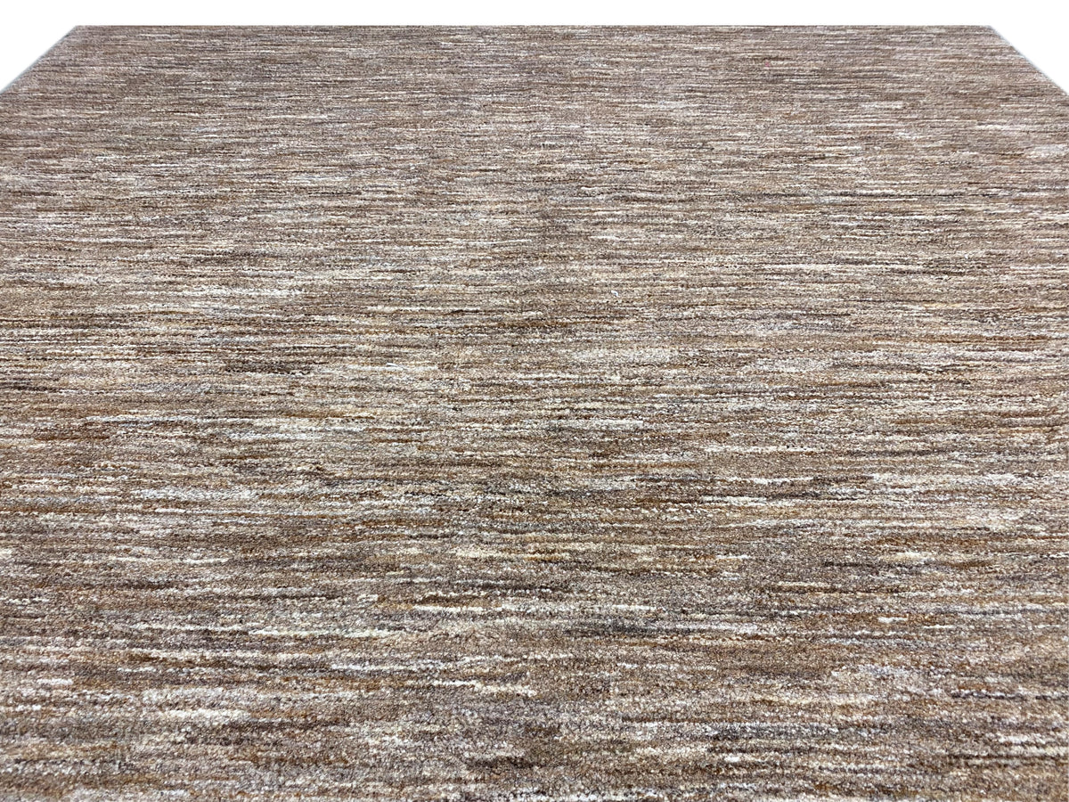 Primo piano di un tappeto Gabbeh: raffinato gioco di linee, pelo corto marrone e beige