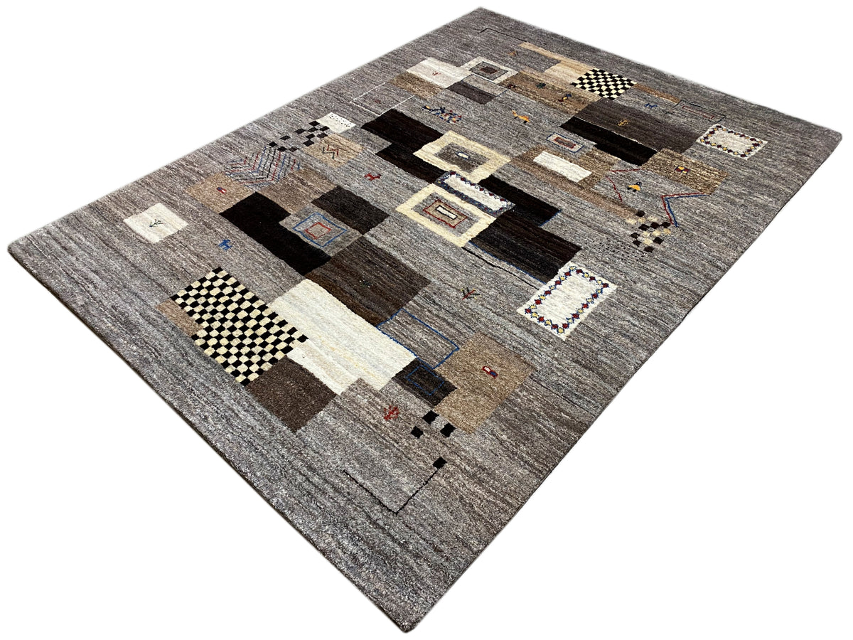Tappeto Gabbeh 235x171 cm, presentato di sbieco: motivi patchwork in grigio e marrone scuro