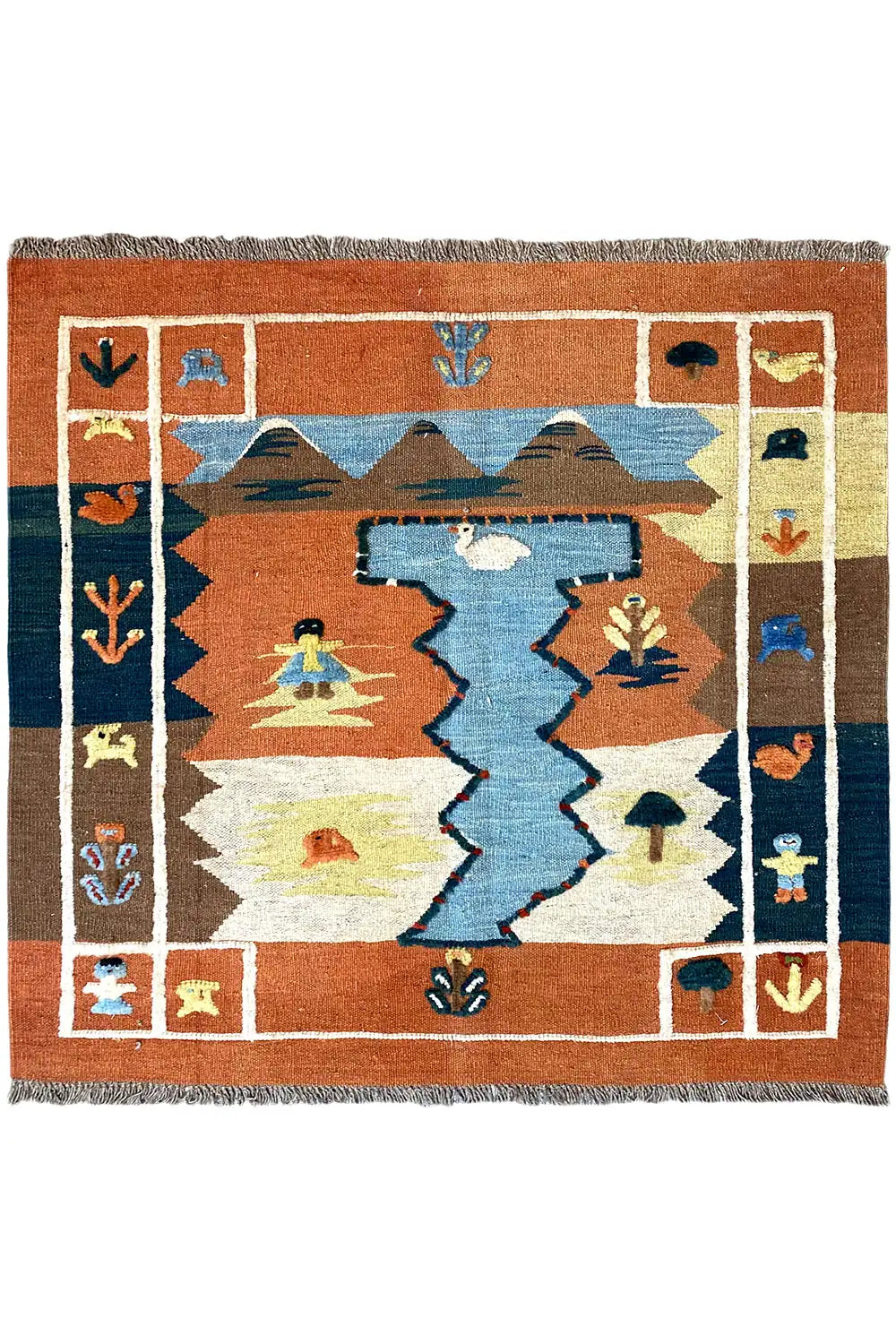 Tappeto kilim con motivo geometrico nei toni terracotta, blu e crema, con frange