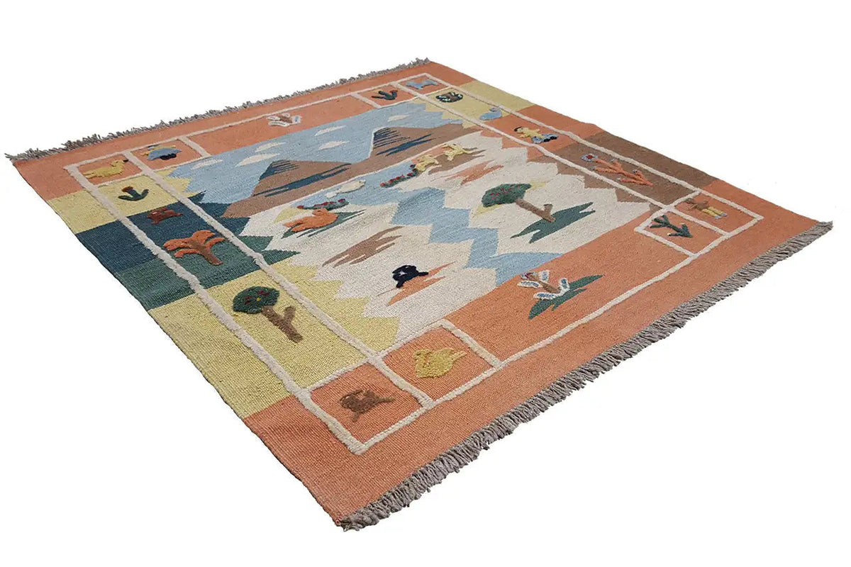 Tappeto kilim steso; campo centrale blu con animali e alberi, bordo arancione, frange