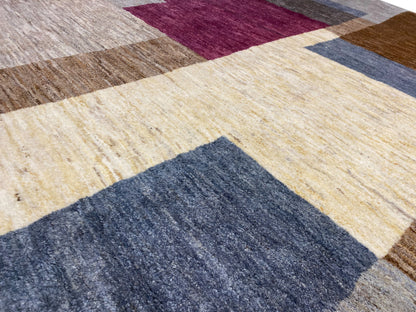 Detail vom Gabbeh-Teppich: leuchtendes creme, bordeauxes und blaues Blockfeld, gewebte Textur