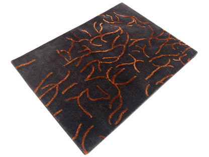 Tappeto di design grigio scuro con motivo astratto arancione, quadrato visto da un’angolazione