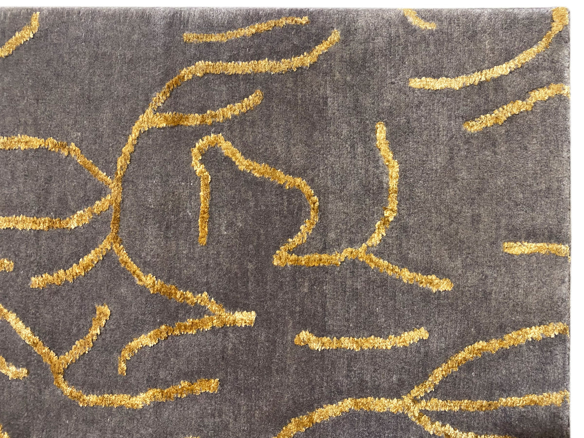Designer-Teppich Detail: graues Gewebe mit gelber abstrakter Linienstickerei