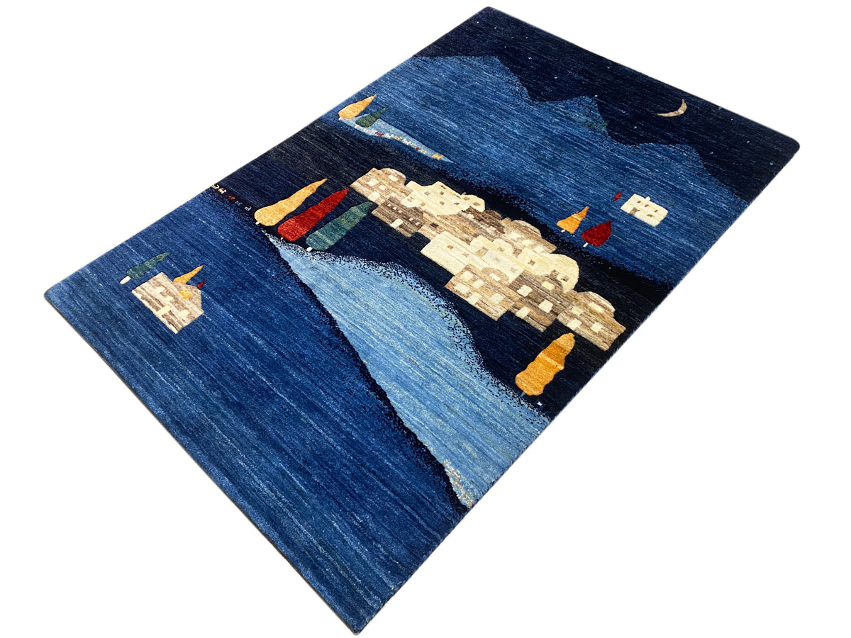 Gabbeh-Luri Teppich, blaues Wellen- und Bergmotiv mit Häusern und kleinen bunten Elementen.