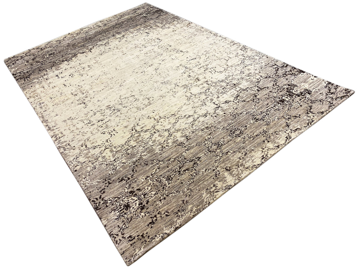 Diagonal ausgerichteter Teppich in Beige und Dunkelgrau mit abstraktem Muster