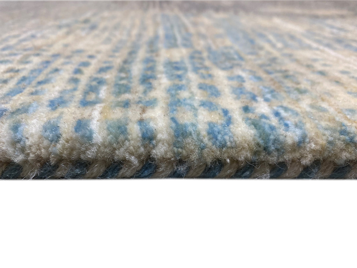 Teppichkante mit dichtem Flor, blau-graue Muster und beiger Untergrund