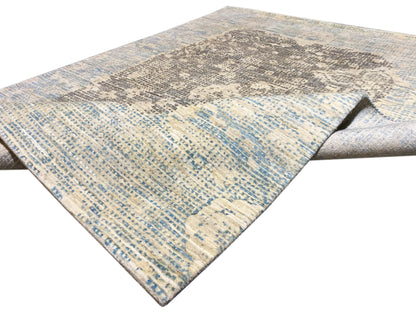 Teppich in Blau-Grau mit diagonaler Musterfläche und leicht gesäumter Kante