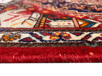 Detail des Teppichflors: roter Florstreifen und mehrfarbige Ornamente am Rand