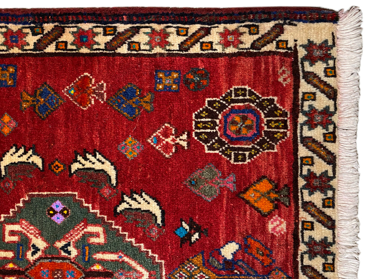 Vista ravvicinata del tappeto Poshti 58x57 cm: pelo rosso con ornamenti e bordo con frange