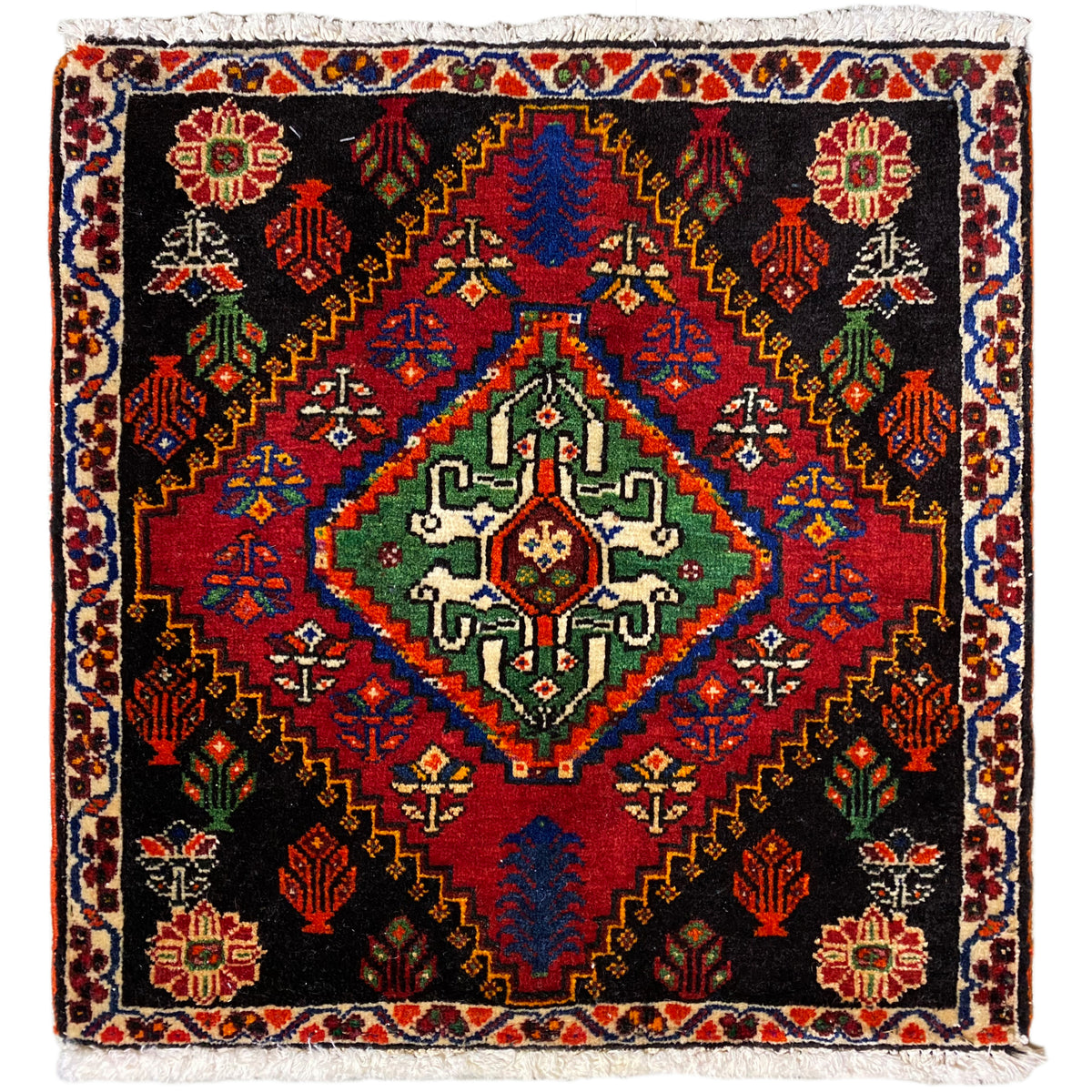 Tappeto Poshti 56x56 cm con fondo nero, ornamenti colorati e frange decorative