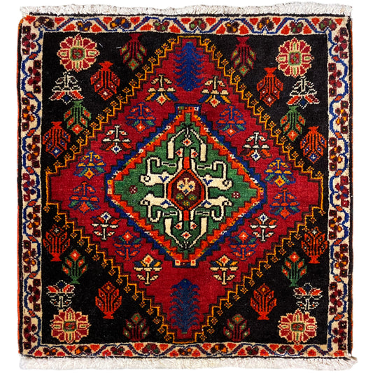 Tappeto Poshti 56x56 cm con fondo nero, ornamenti colorati e frange decorative