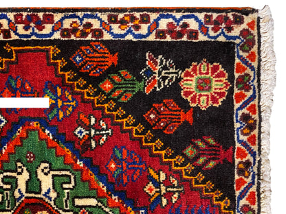 Tappeto Poshti 56x56 cm, vista ravvicinata: bordo ornamentale con rombi colorati su fondo nero