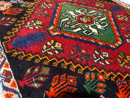 Vista dettagliata di un angolo del tappeto Poshti: ornamenti geometrici multicolori su fondo nero
