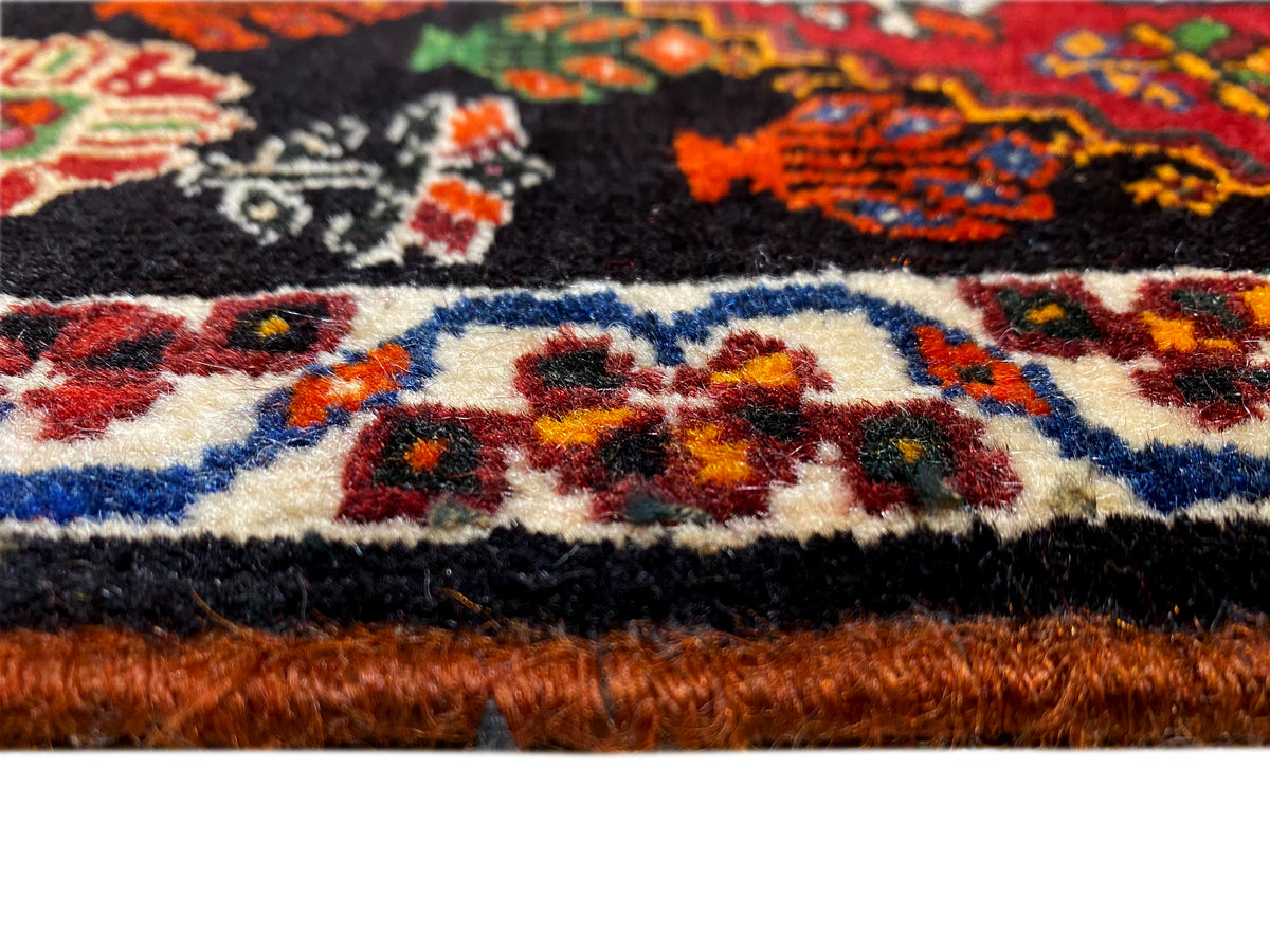 Dettaglio del bordo del tappeto Poshti: bordura multicolore e vello del tappeto sul bordo inferiore