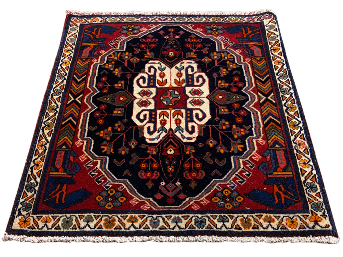 Tappeto Poshti rettangolare con sfondo blu e motivo ornamentale simmetrico