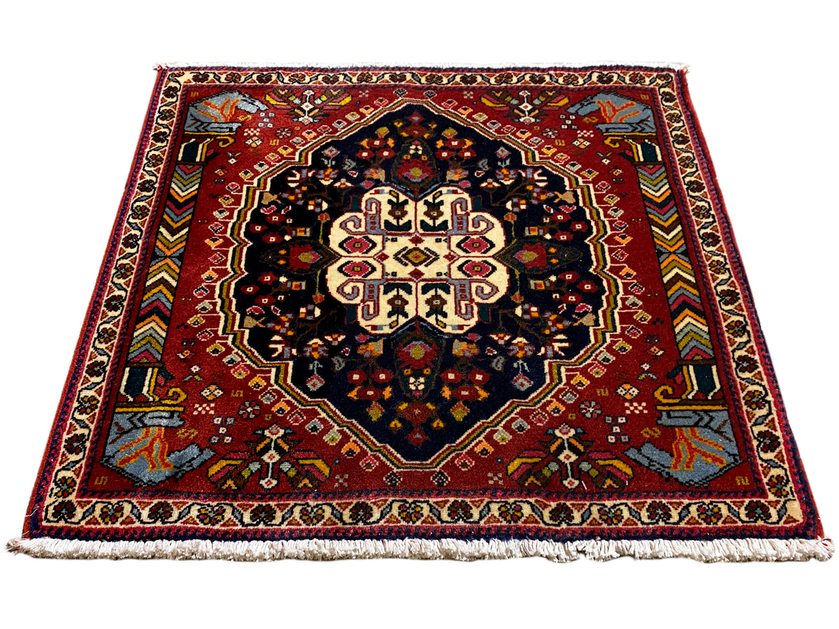 Tappeto Poshti con fondo rosso e medaglione simmetrico, superficie di contrasto blu-nera