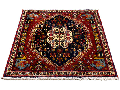 Tappeto Poshti con fondo rosso e medaglione simmetrico, superficie di contrasto blu-nera