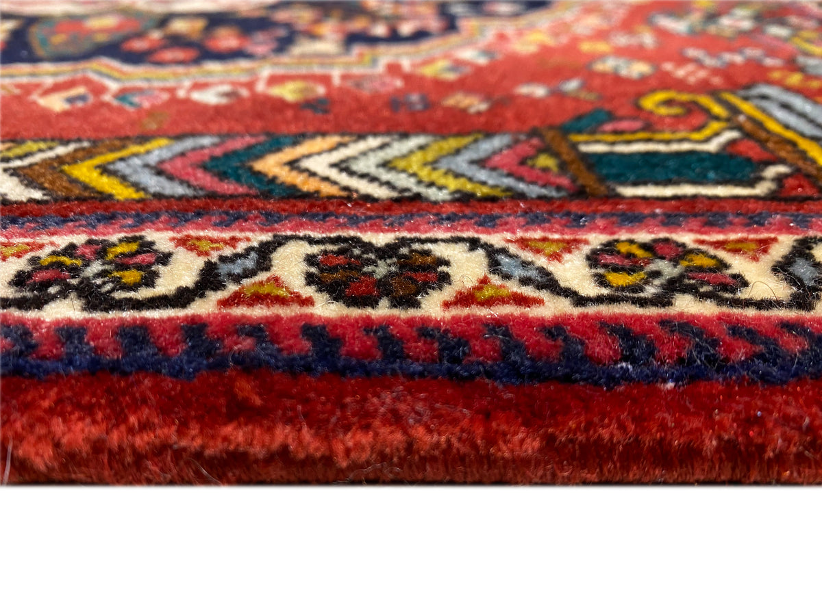 Dettaglio dell'orlo del tappeto Poshti con frange rosse e blu e motivi intrecciati