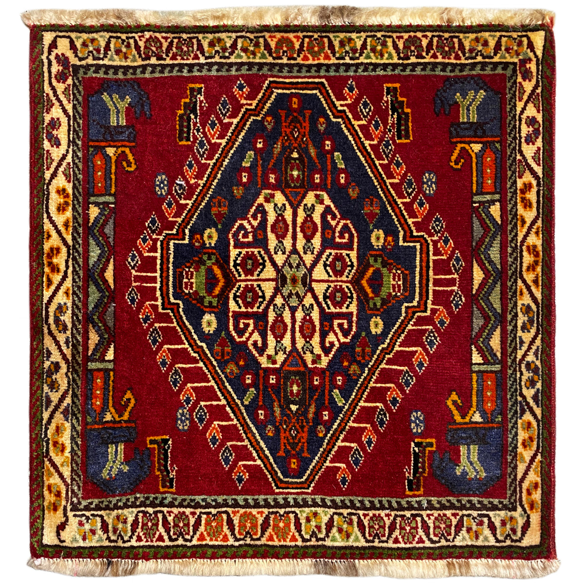 Tappeto Poshti (59×61 cm) con motivo geometrico rosso, bordi multicolori e frange