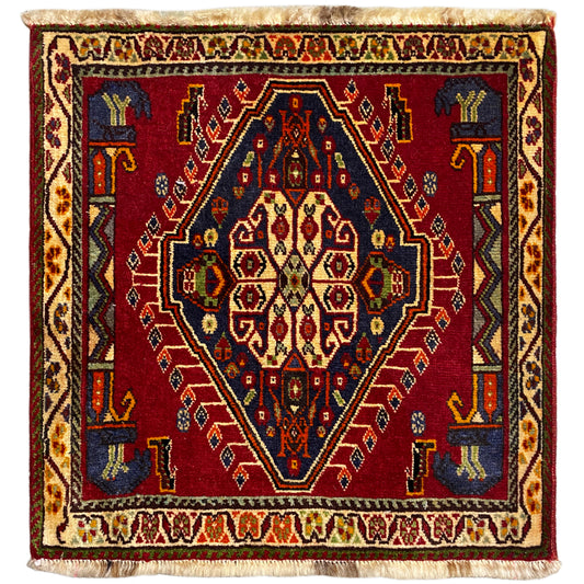 Tappeto Poshti (59×61 cm) con motivo geometrico rosso, bordi multicolori e frange