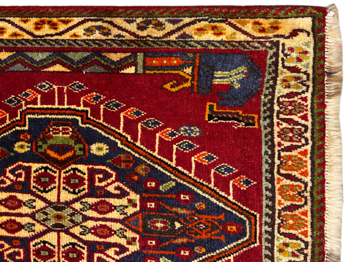 Dettaglio del tappeto Poshti (59×61 cm): campo rosso con ornamenti del tappeto e bordo profilato
