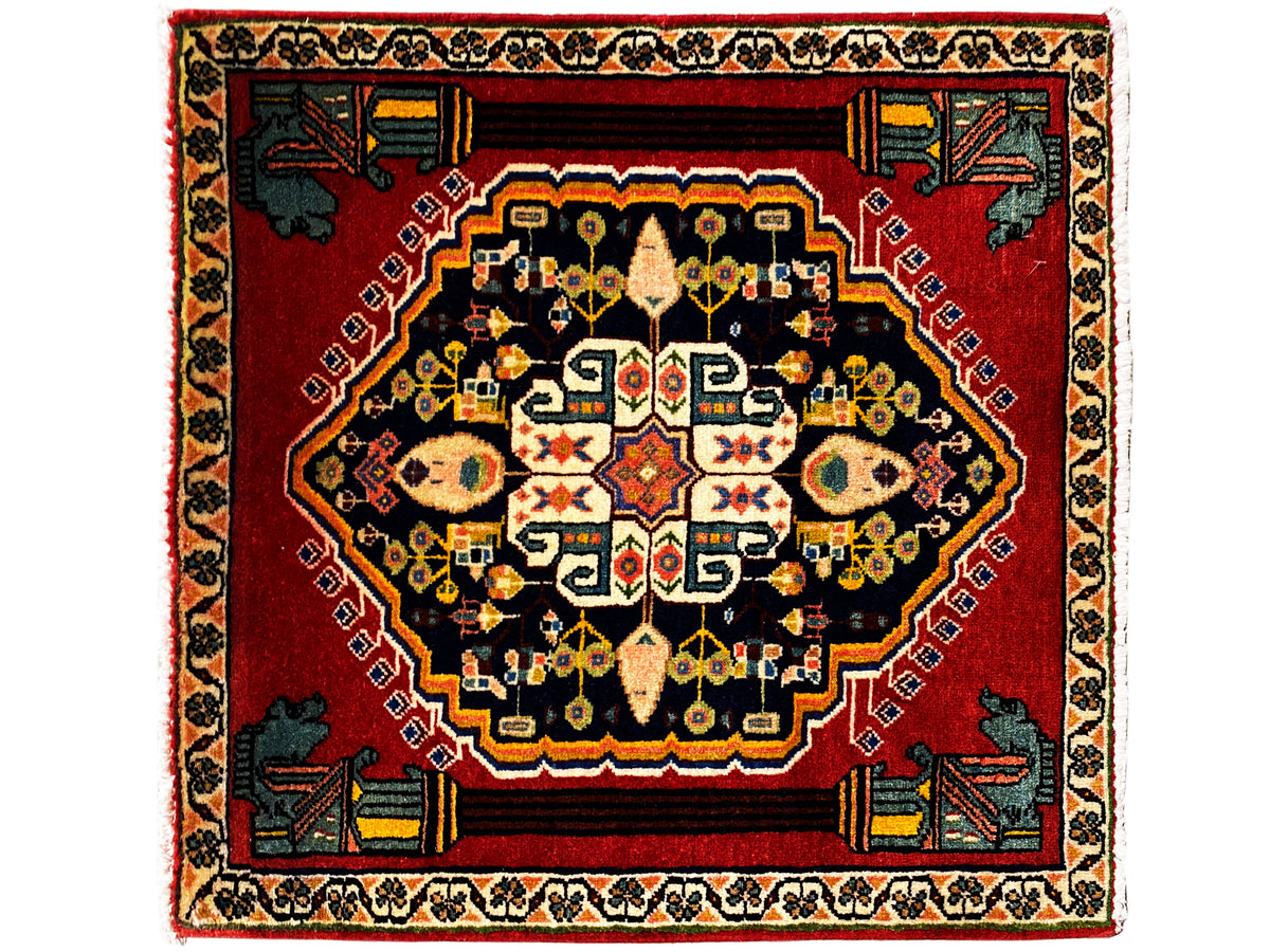 Tappeto Poshti con fondo rosso, medaglione scuro e motivi colorati al centro