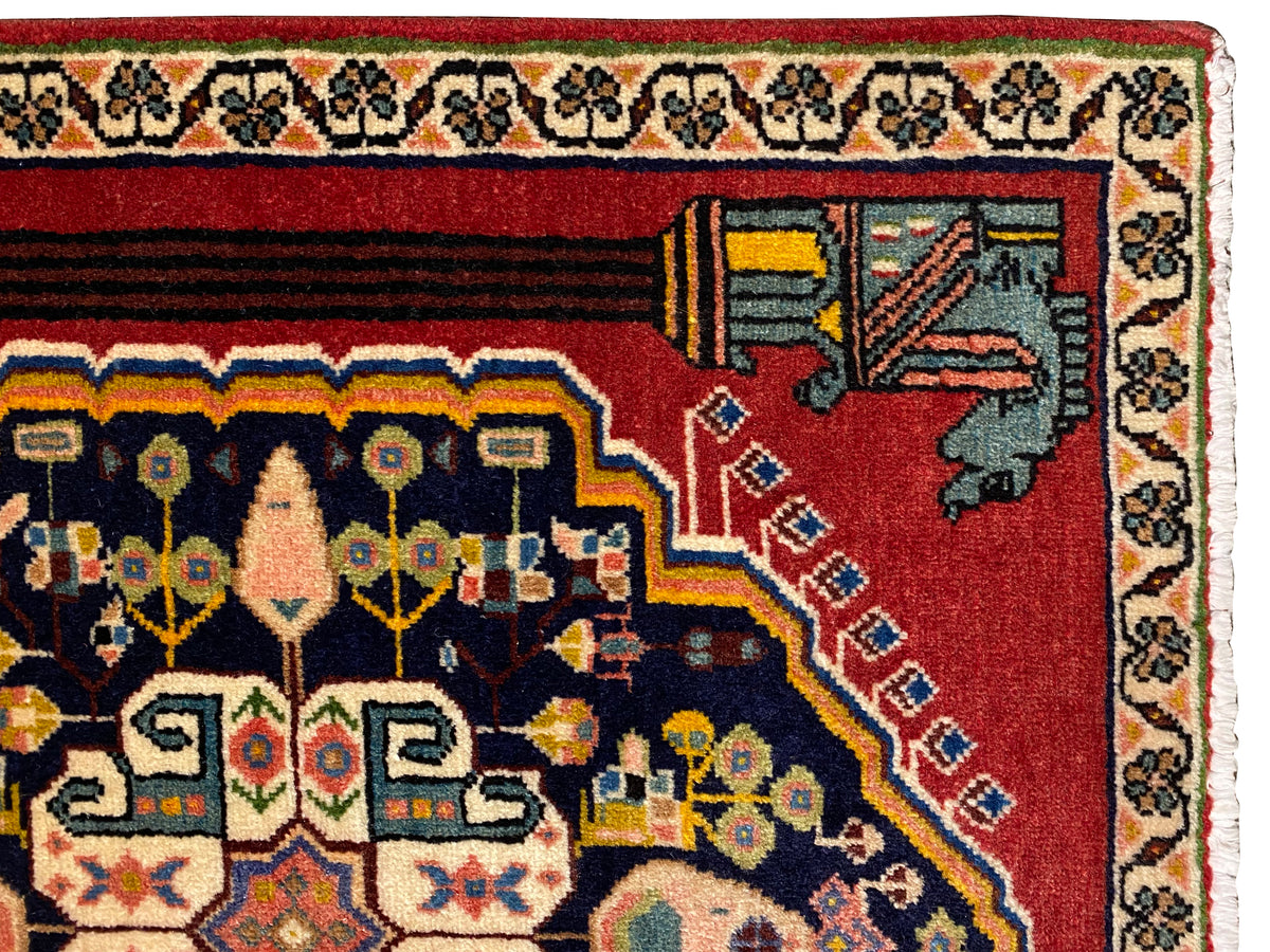 Vista ravvicinata del tappeto Poshti: bordo rosso con motivi angolari decorativi e fasce ornamentali
