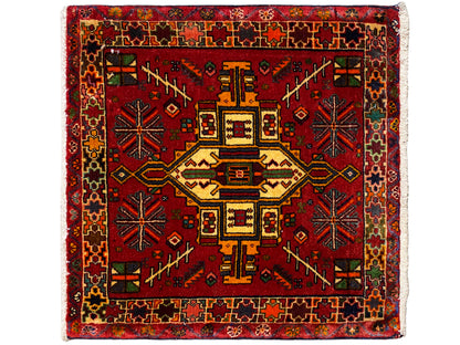 Tappeto Poshti rettangolare con sfondo rosso e motivo centrale geometrico multicolore