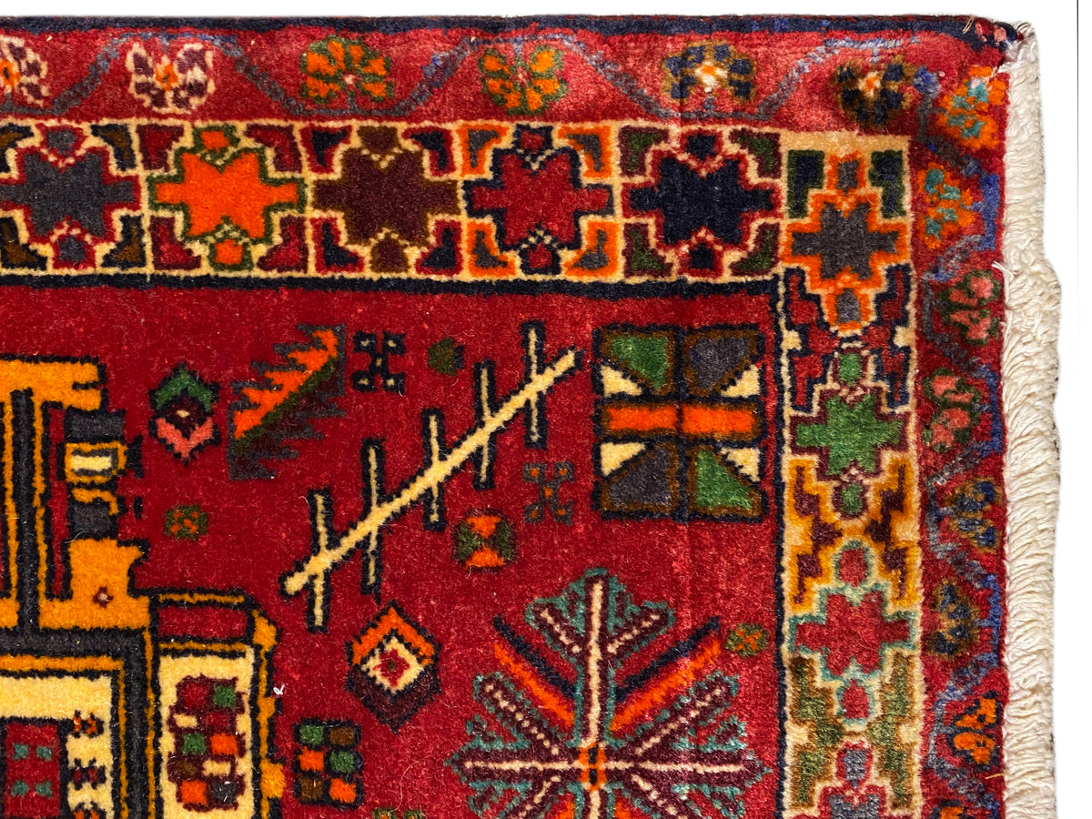 Primo piano: tappeto Poshti con fondo rosso, ornamenti colorati e bordo multicolore