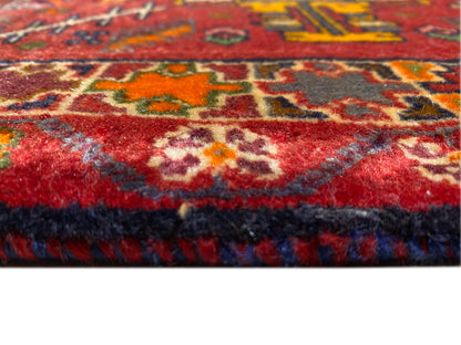 Primo piano del bordo del tappeto con pelo rosso e bordo multicolore
