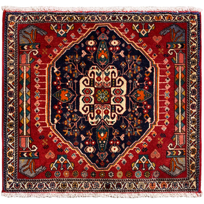 Tappeto quadrato con sfondo rosso e motivo centrale blu scuro, con frange