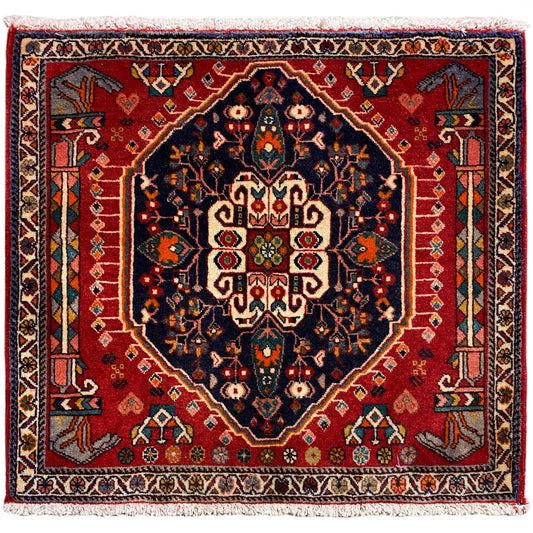 Tappeto quadrato con sfondo rosso e motivo centrale blu scuro, con frange