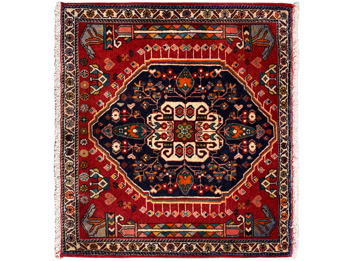 Tappeto a fondo rosso, con medaglione blu scuro e bordo multicolore, quadrato