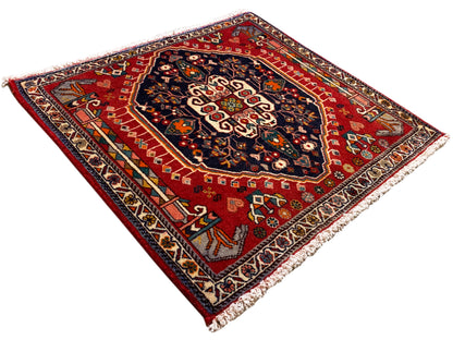 Tappeto a fondo rosso con motivo ornamentale blu, rettangolare, con frange