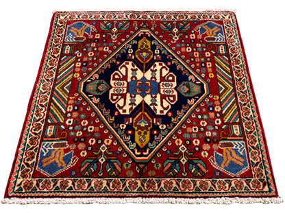 Tappeto 66x62 cm con motivo rosso, bordo scuro e ornamenti colorati