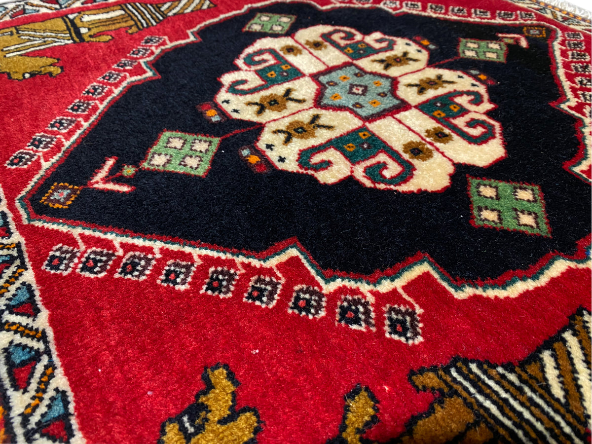 Tappeto Poshti 63x55 cm: primo piano del medaglione centrale con motivo rosso e nero
