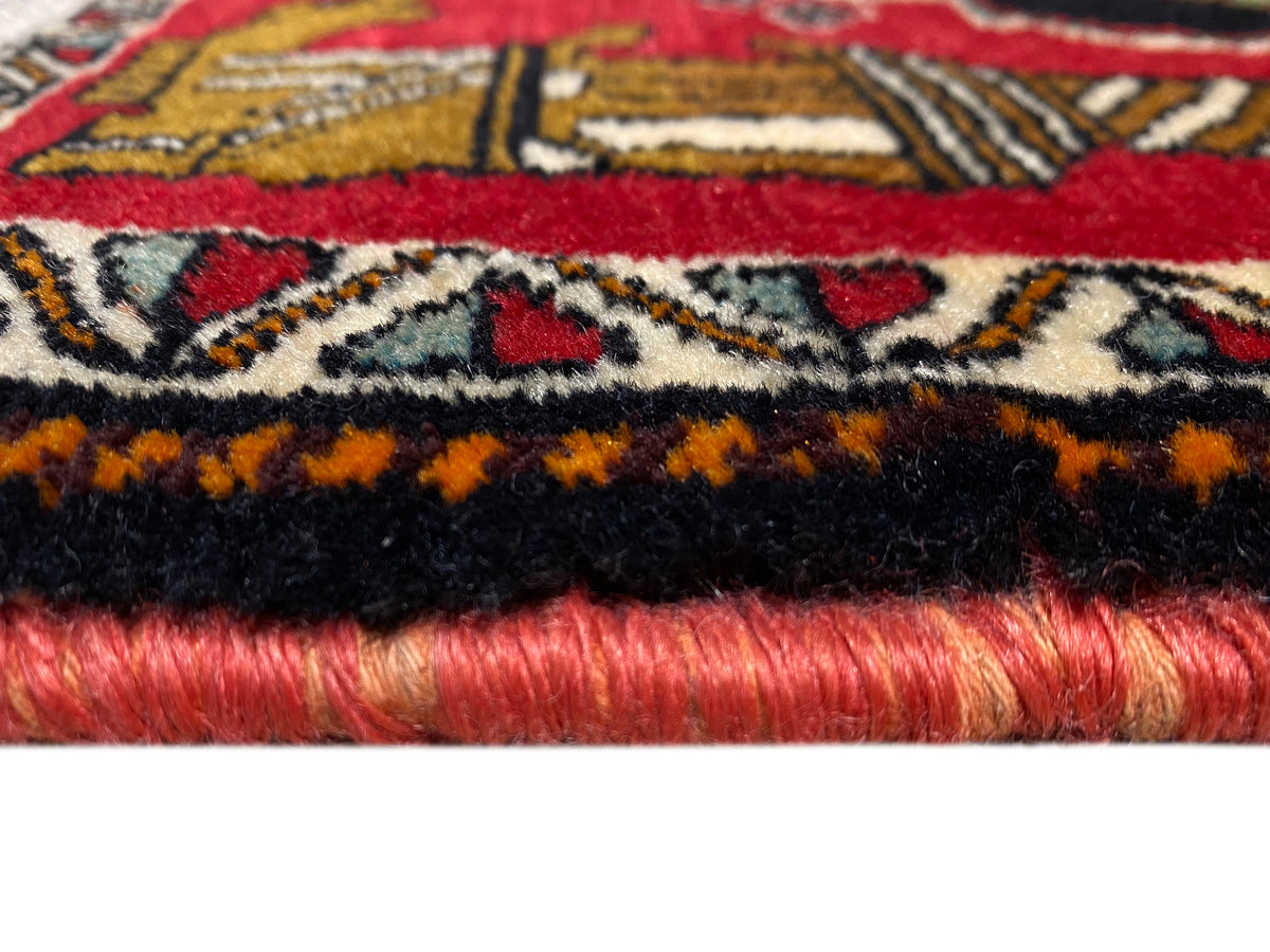 Tappeto Poshti 63x55 cm: dettaglio del bordo del tappeto con frange, bordatura nera e pelo rosso