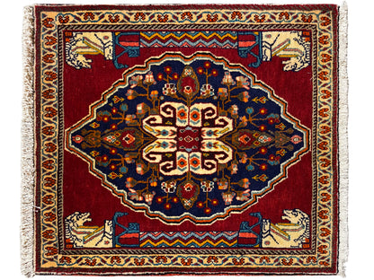 Tappeto rettangolare con fondo rosso, ornamenti blu scuro e bordature decorative beige